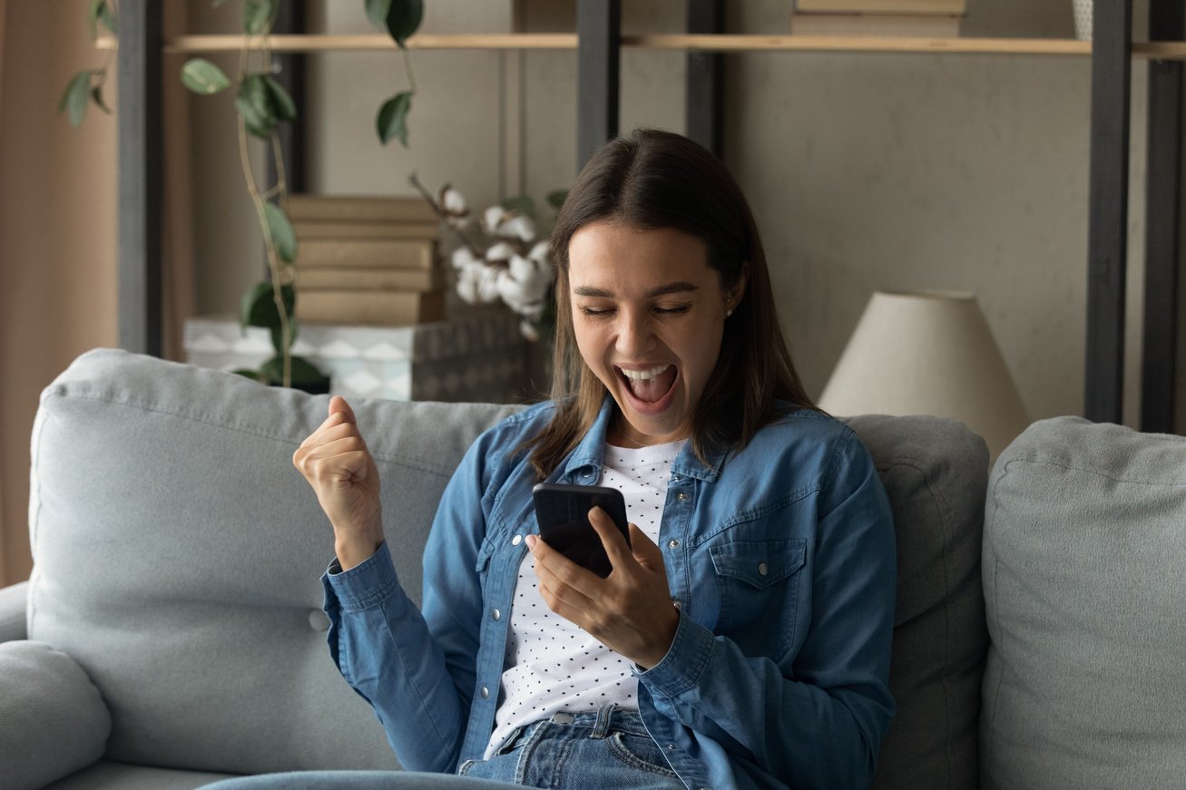 Amazed millennial female hold smartphone reading perfect job offer